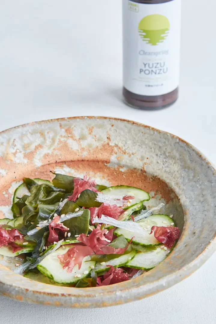 Blattsalat mit Gurke und Sesam, nebenstehend die Soja Sauce , Yuzu Ponzu Sauce, 150ml aus der Flasche